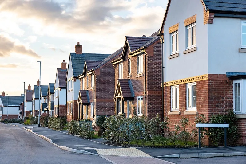 Residential street with modern houses and well-maintained gardens, representing areas served by Environ Drainage Services in London.