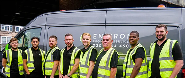 Team of drainage specialists from Environ Drainage Services in high-visibility vests standing next to branded service van, showcasing expertise in drainage solutions.